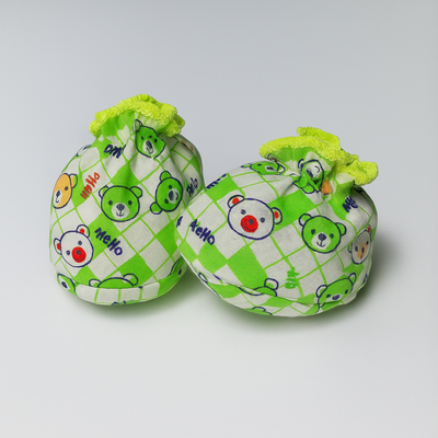 Pair of green and white checkered baby booties with cartoon bear design on a light gray background