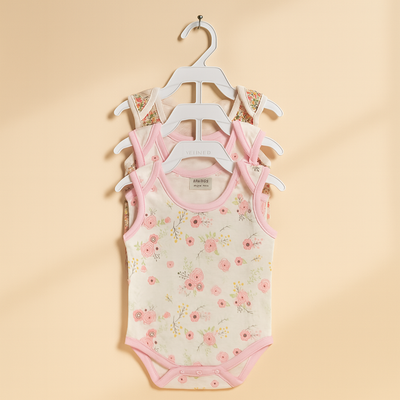 Floral-patterned baby bodysuit on a hanger against a beige background